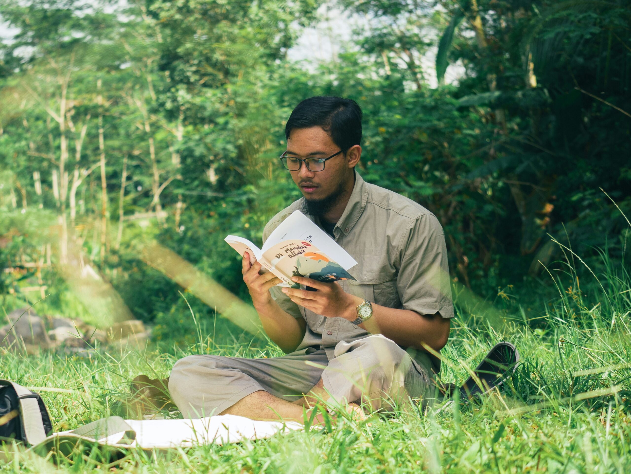Man reading book in grass